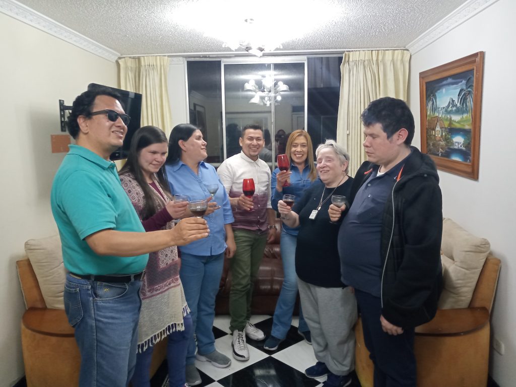 Foto integrantes del equipo en semicírculo, levantando las copas dispuestos a brindar.